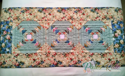 Quilted bedrunner with geometric pattern on flower splashed background.